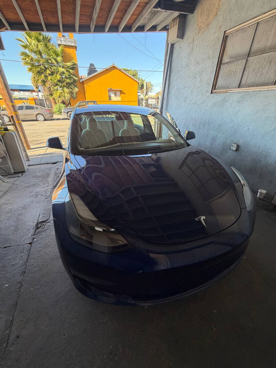 Blue Tesla Model 3 — before tint, front view
